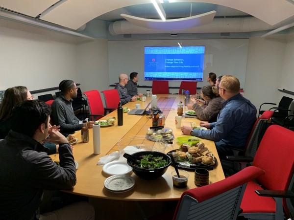 Group of people eating healthy lunch and watching wellness webinar